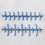 Barb stitch front side - embroidery in blue and yellow thread on white fabric Barb stitch front side - embroidery in blue and yellow thread on white fabric